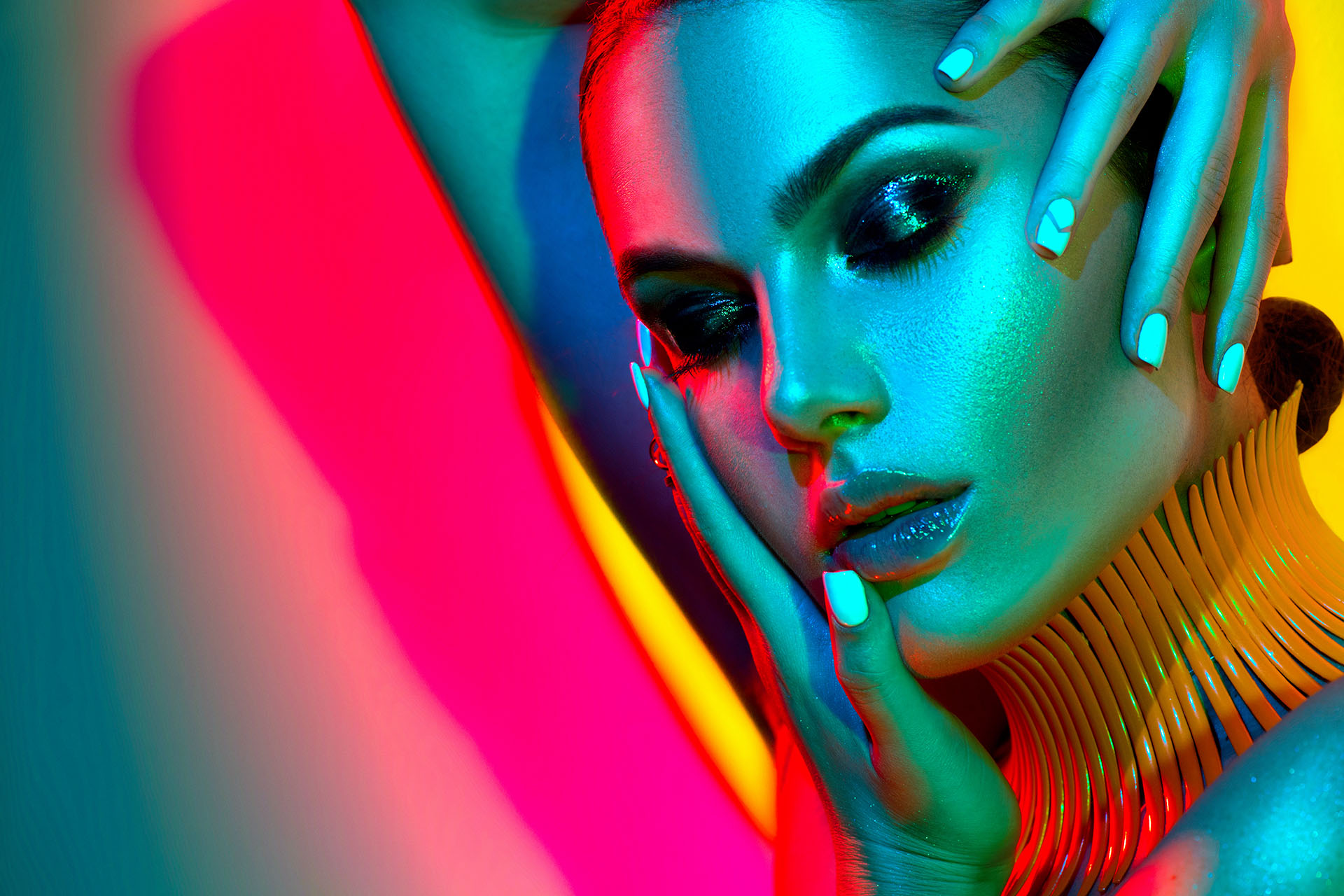 High Fashion model woman in colorful bright lights posing in studio