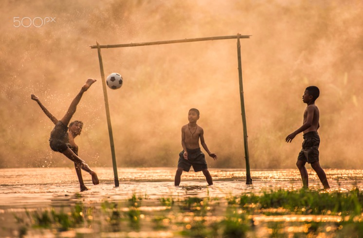Asia Boy kicking a soccer ball