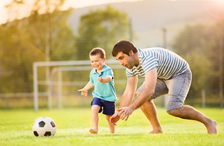 Father and son playing football