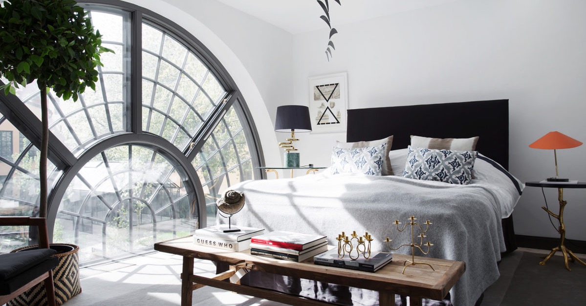 Bedroom with a large spiral window in an apartment inside a converted 17th-century Swedish brewery
