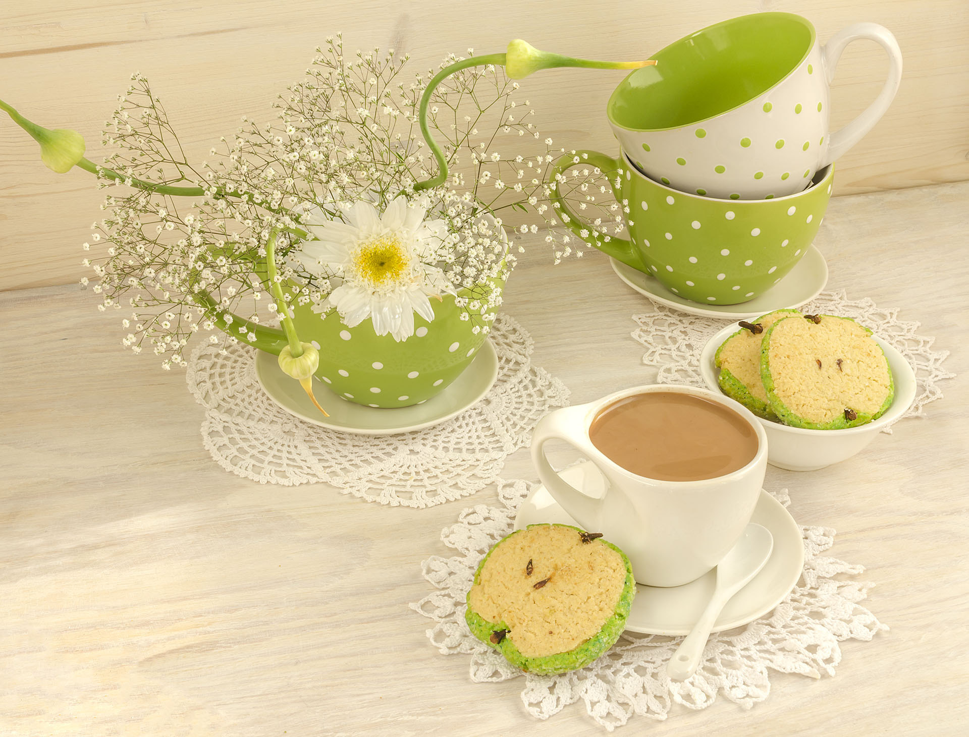 Bouquet of white flowers in a green polka dot cup, cocoa with milk and apple shaped cookies for mother's day