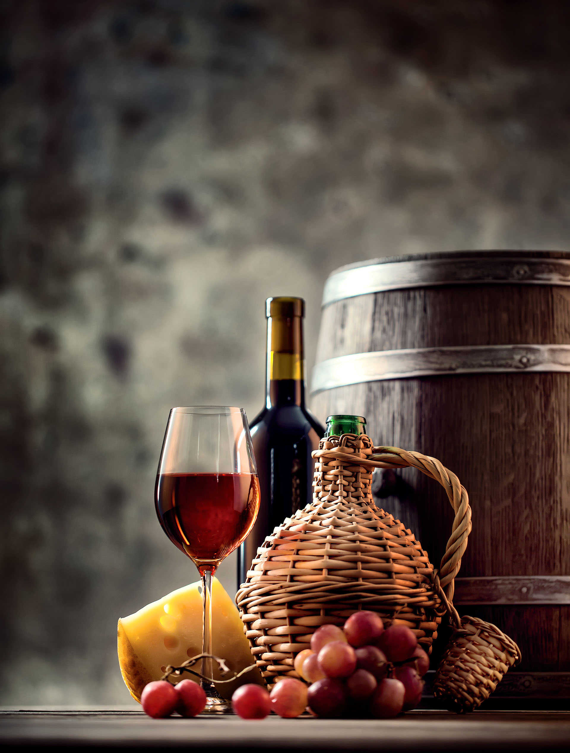 Glass, bottle, carafe of wine and barrel shot with selective focus
