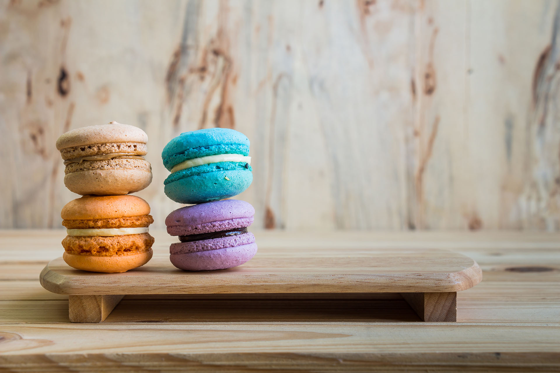 macarons on table over wooden background