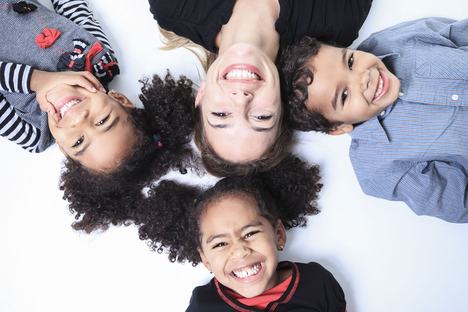 A family lay on the floor of a photography studio