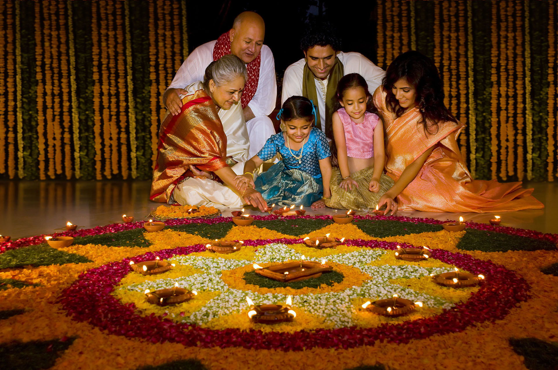 Family sitting near rangoli