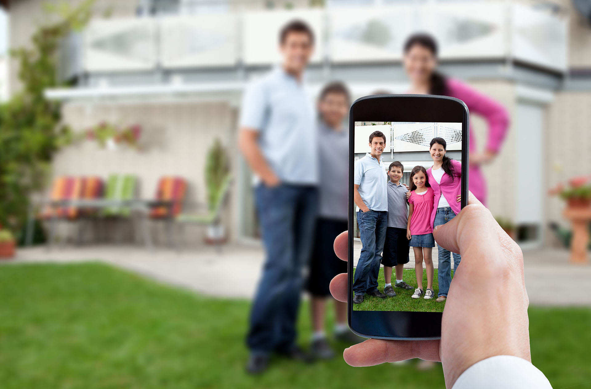 Person Hand Using Mobile Phone For Taking Family Photo