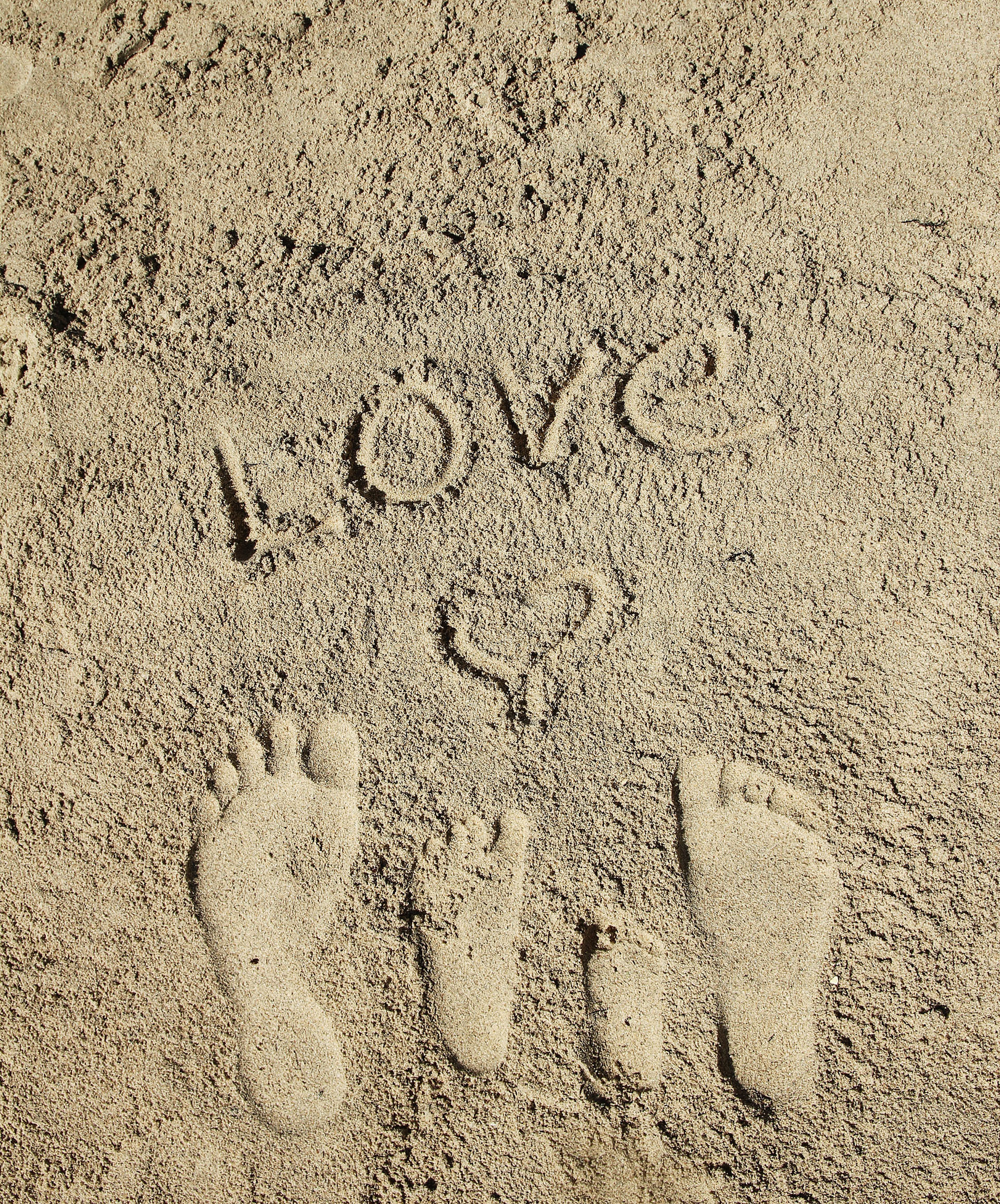 a family footprints in the sand on the beach