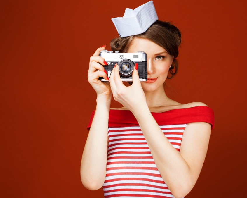 beautiful-pin-up-girl-holding-a-vintage-camera-and-directs-it-straight-to-the-camera