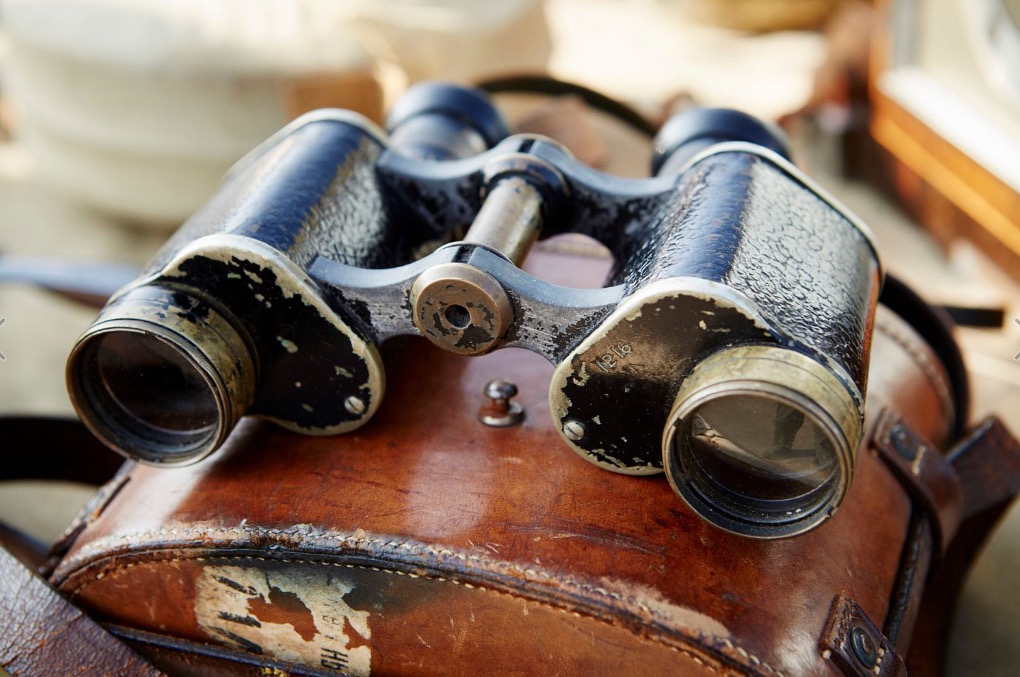 pair-of-vintage-binoculars-with-a-worn-leather-case-at-a-flea-market