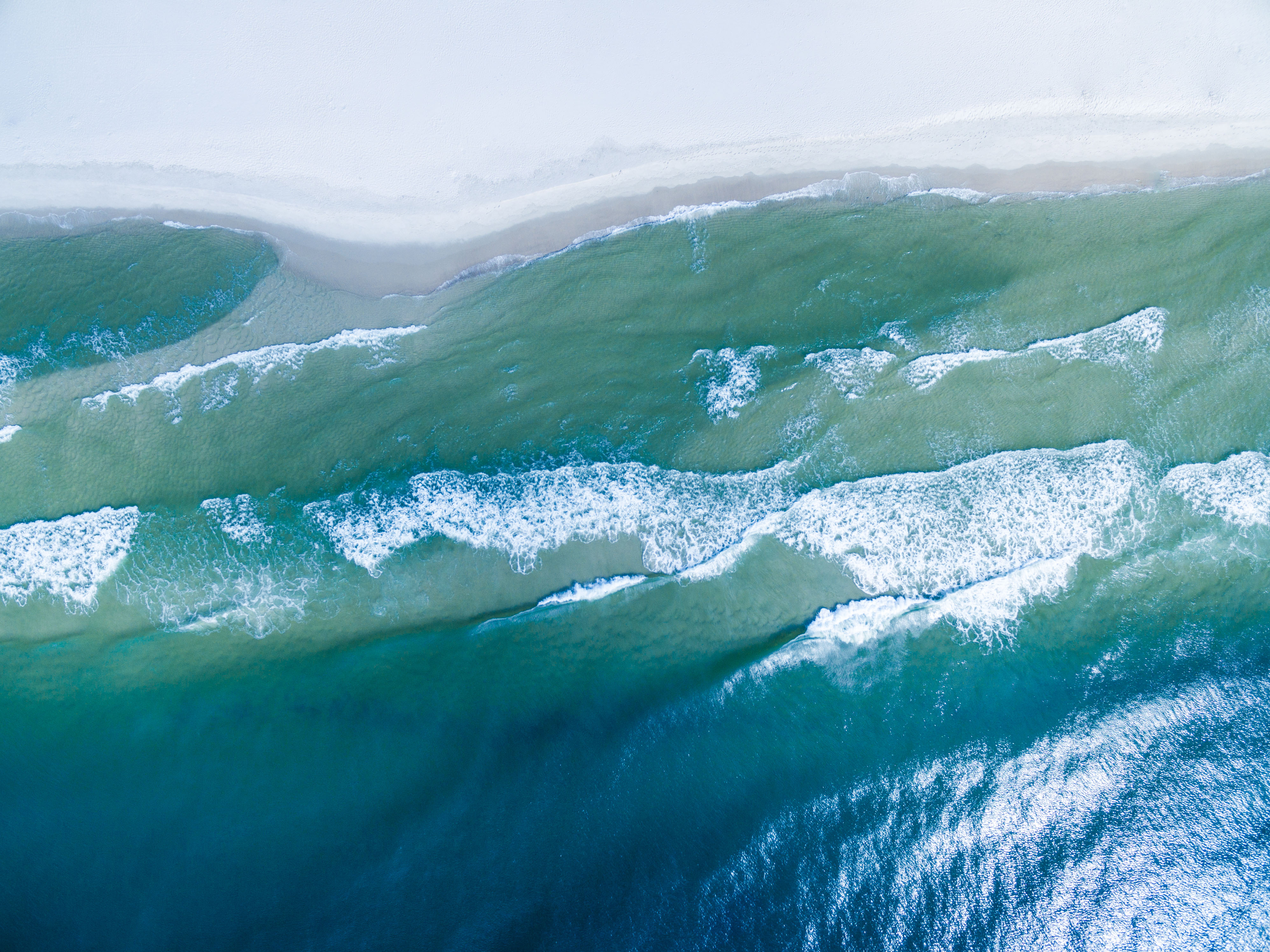 Drone Photograph of the Gulf of Mexico washing ashore on the beautiful white sand beach of Gulf Shores