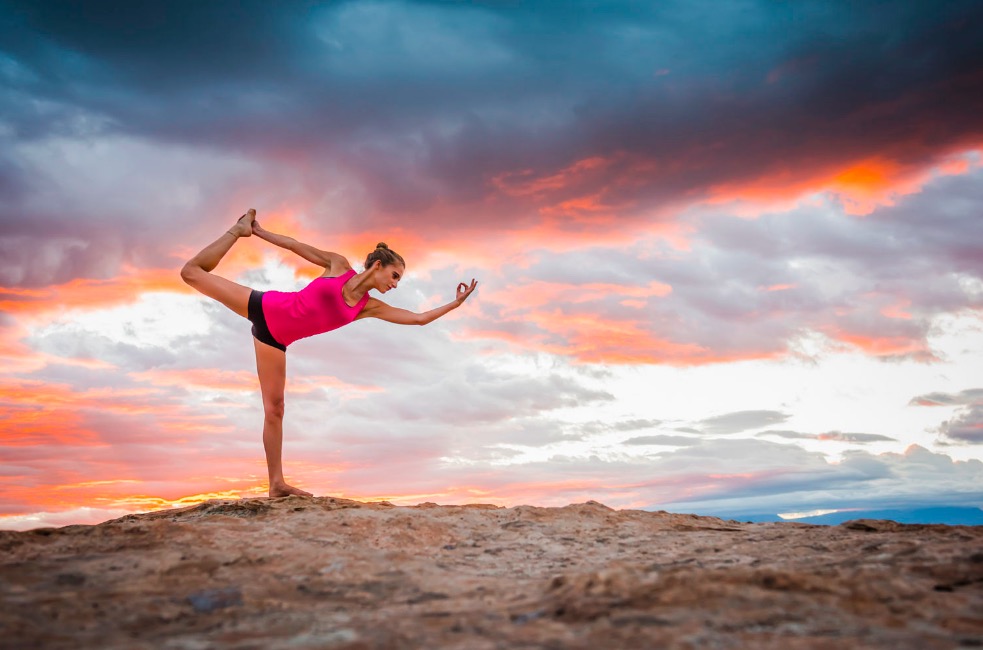 Hispanic woman practicing yoga on remote hilltop