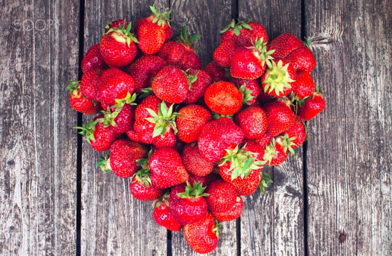 organic-strawberries-heart-on-rustic-wood