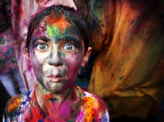 A boy with a colored powder face for the spring festival Holi