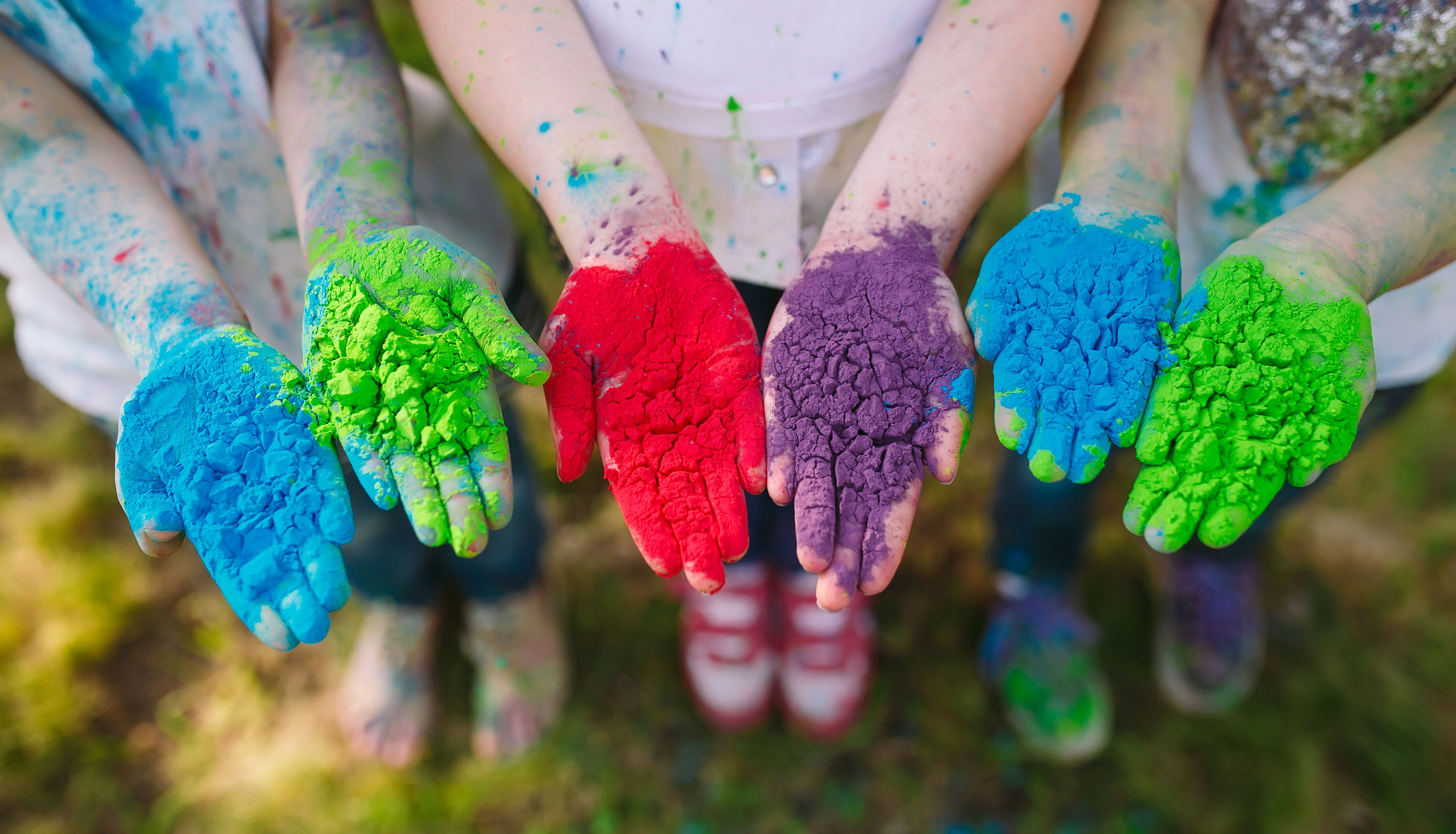Hands _ Palms of young people covered in purple, yellow, red, blue Holi festival colors isolated