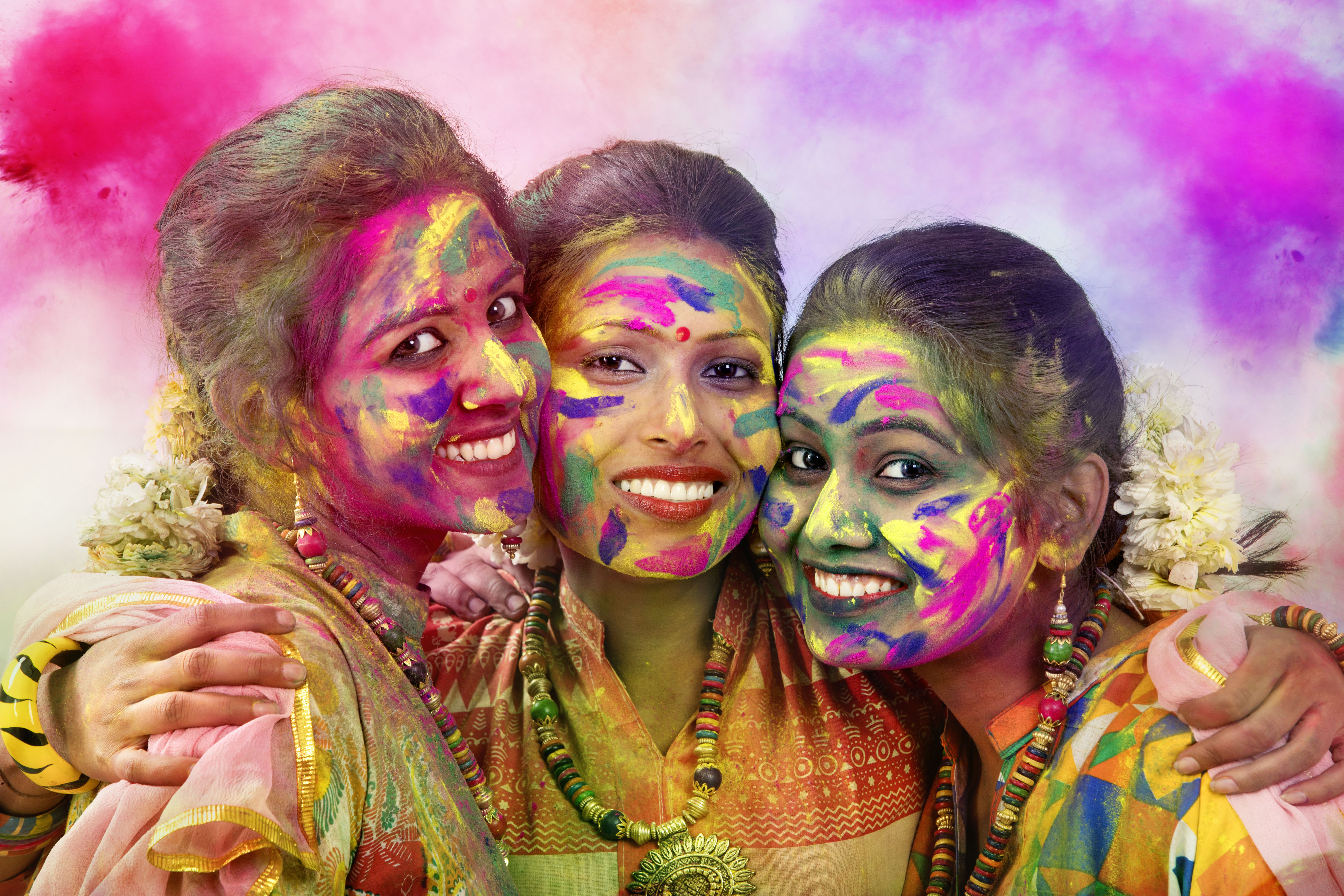 Portrait Of Three Young Indian Women With Colored Face During Holi Color festival