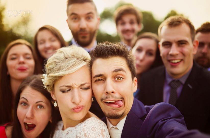 Newlyweds with friends taking selfie