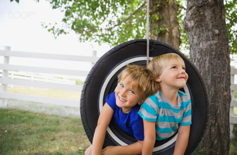 Playful boys on a tire swing