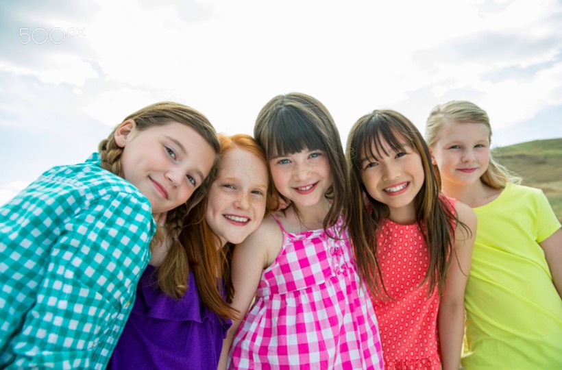 Portrait of happy schoolgirls standing together