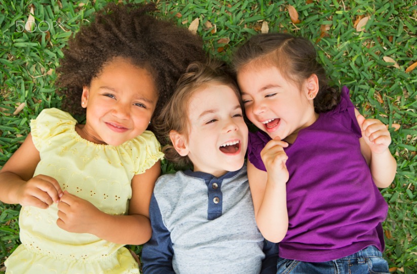 Three children lying on their back