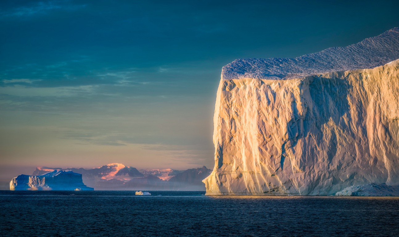 A giant iceberg greeting the sun on an early morning in Eastern Greenland | by hpd-fotografy