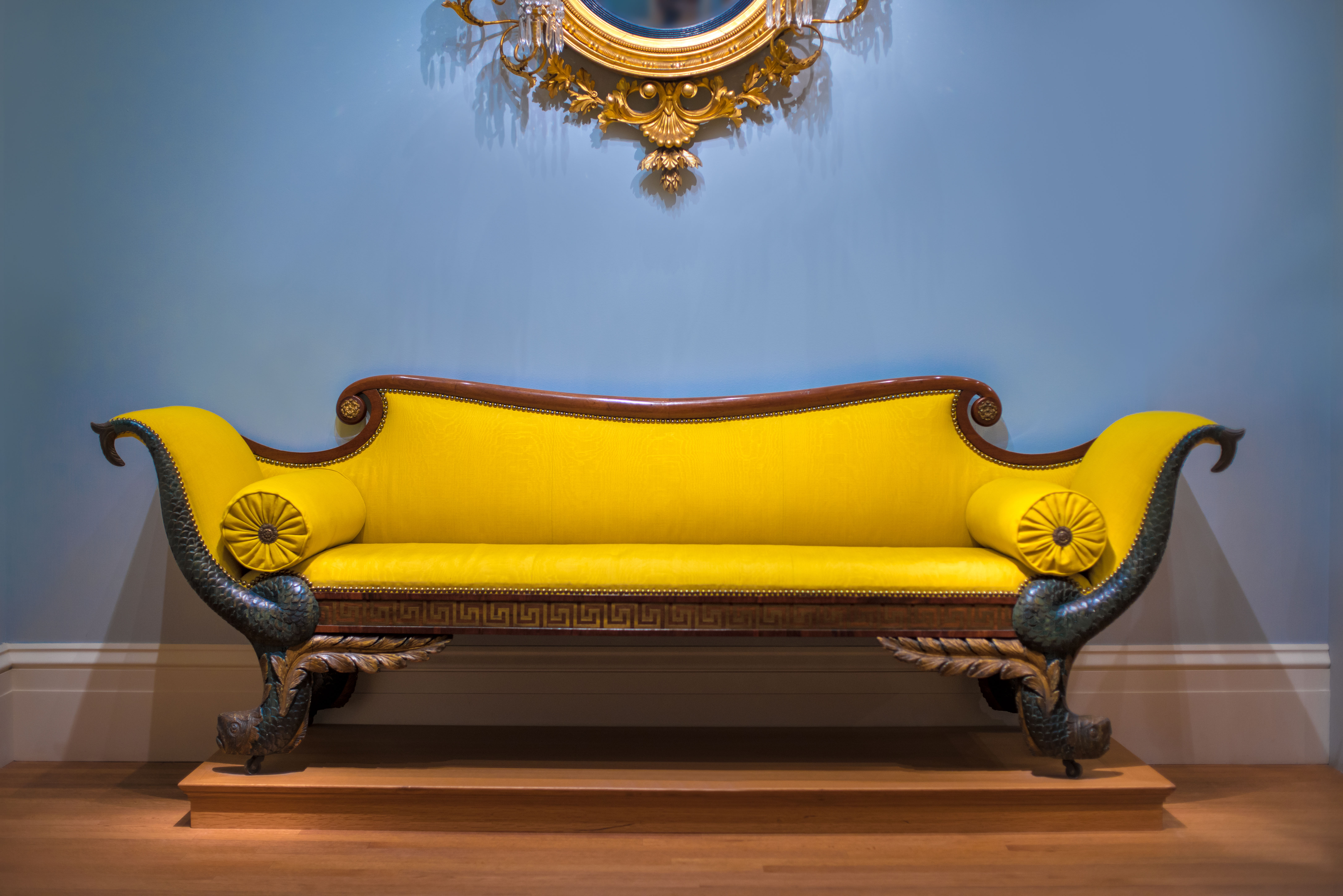 Luxury yellow sofa in front of the blue wall