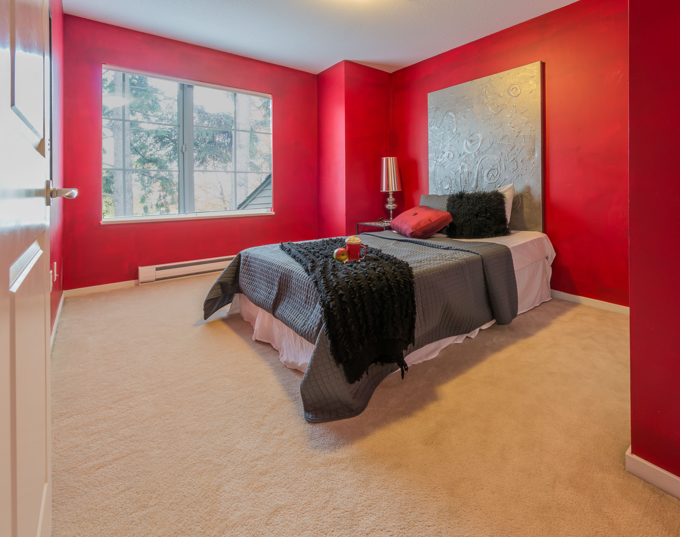 Modern comfortable, nicely decorated, bedroom painted in red. Interior design