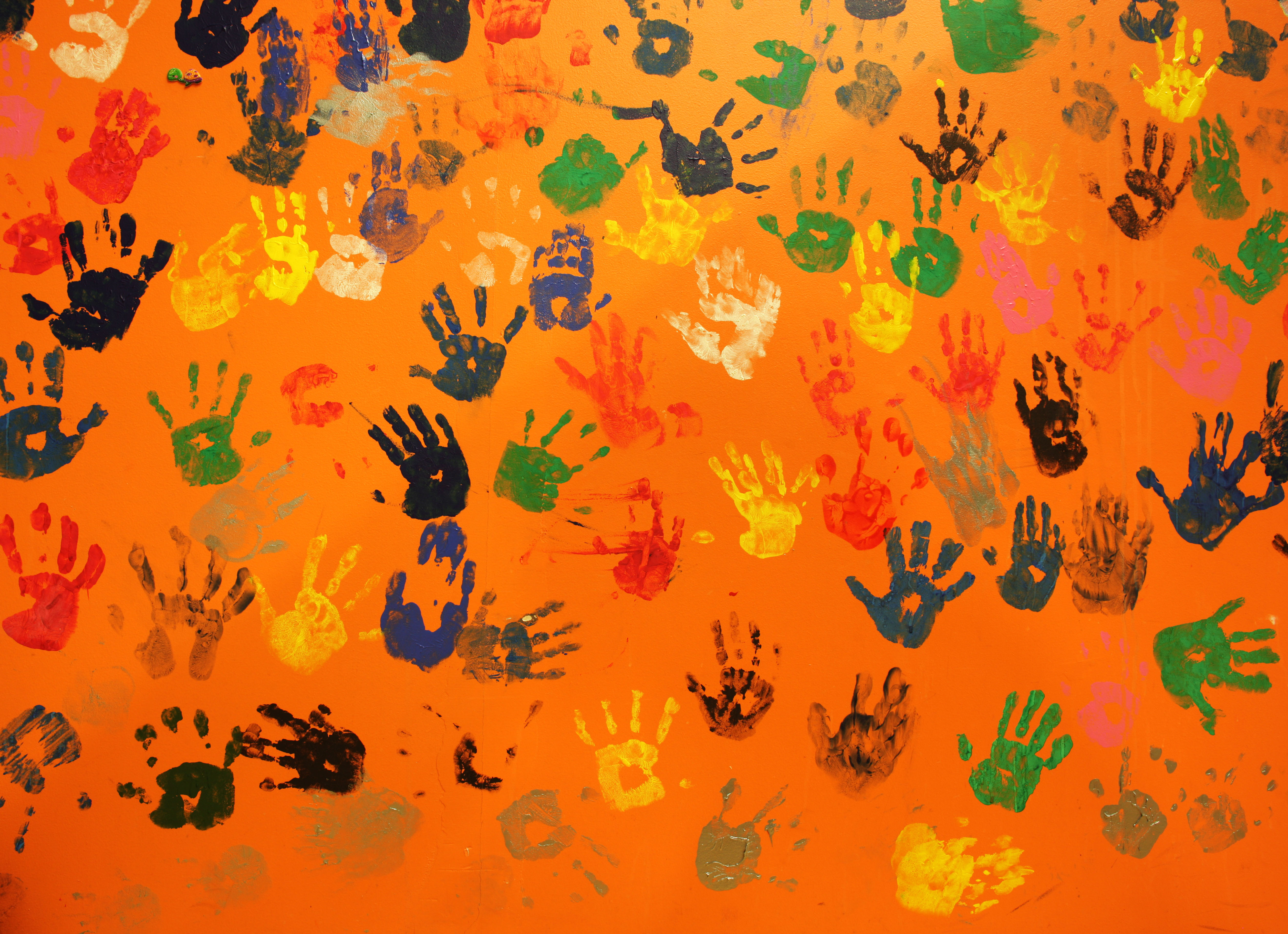 multiple colored hand prints on orange background