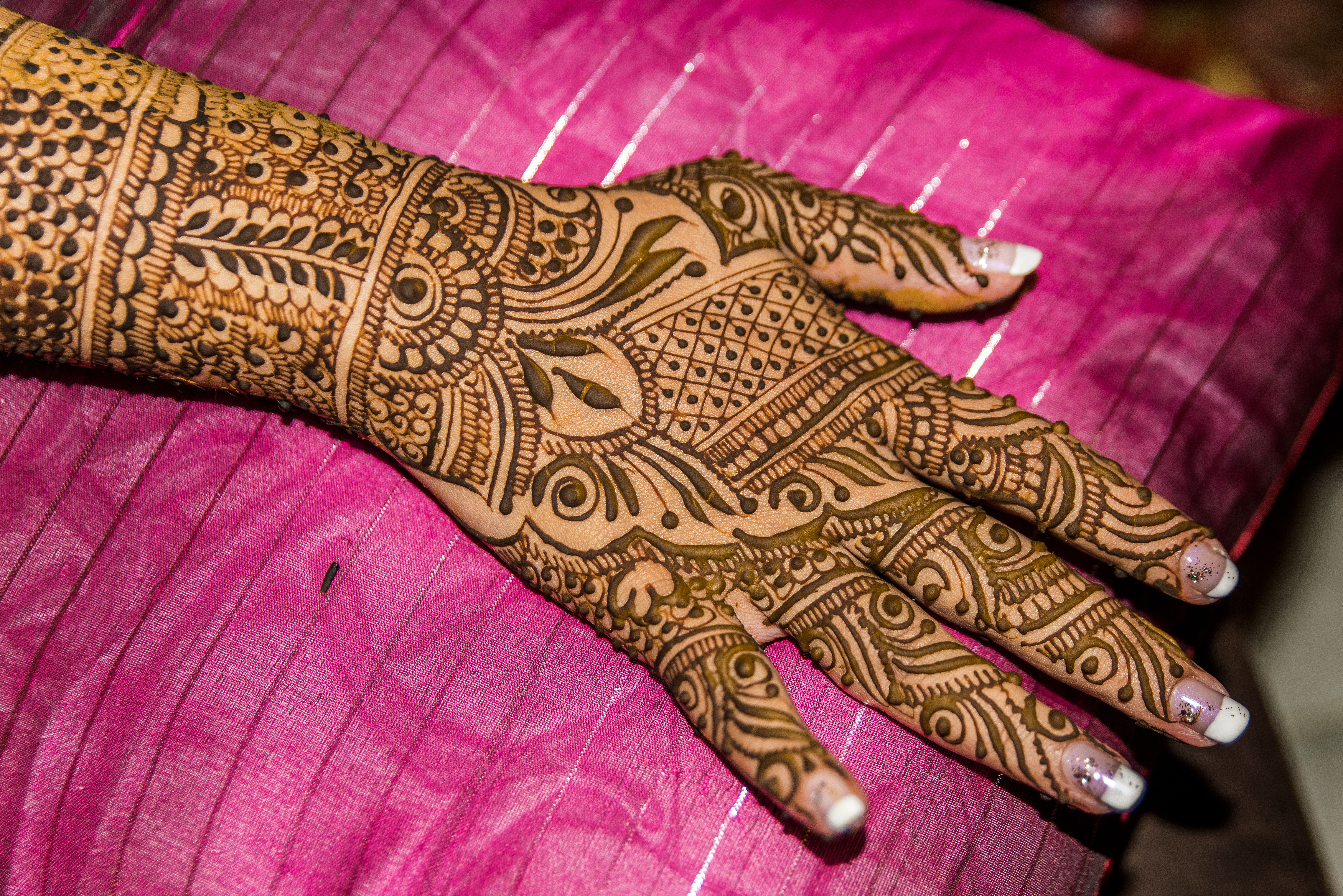 Back of hand, fingers and forearm of Indian bride resting while mehndi is drying