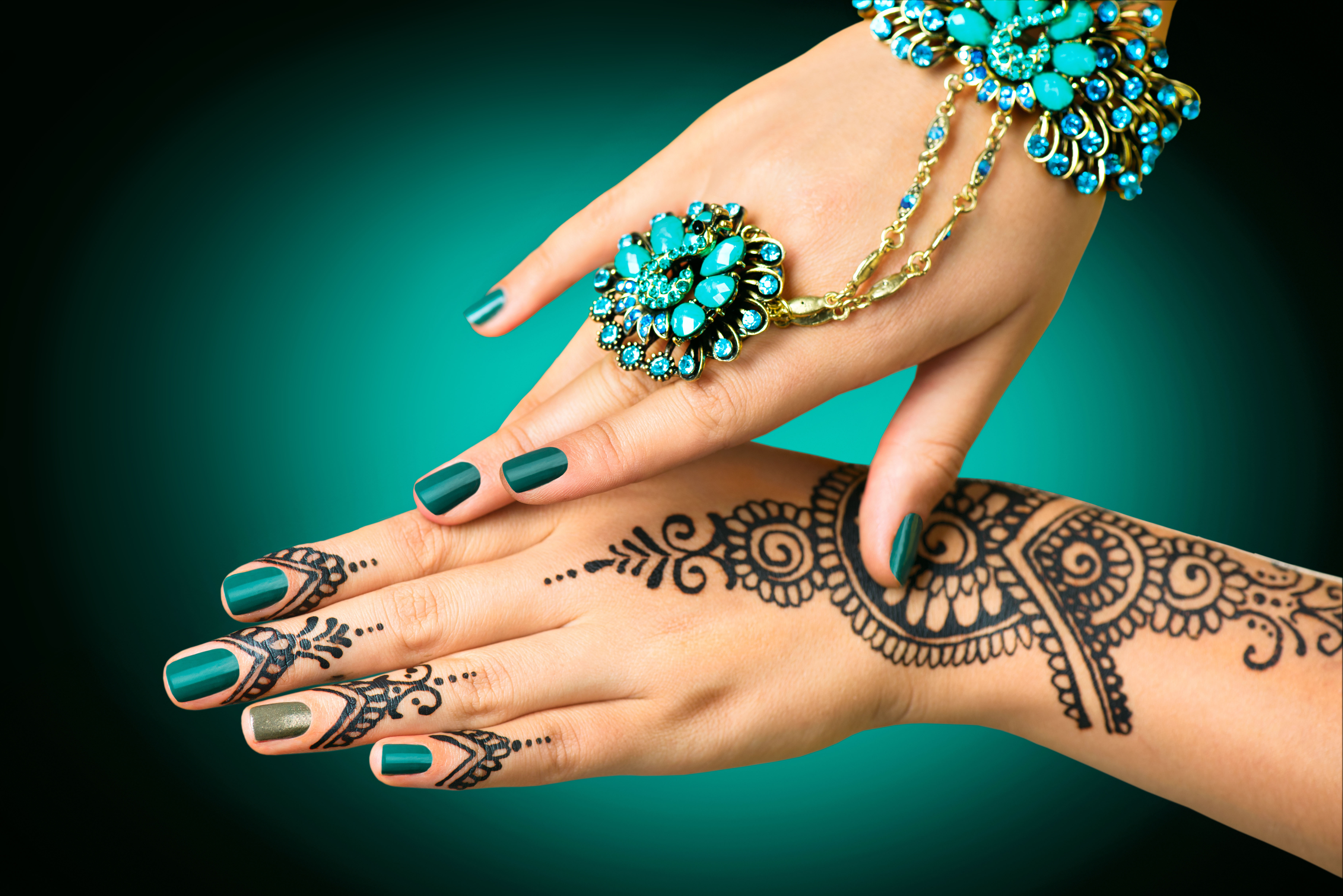 Hand with perfect turquoise manicure and national Indian jewels