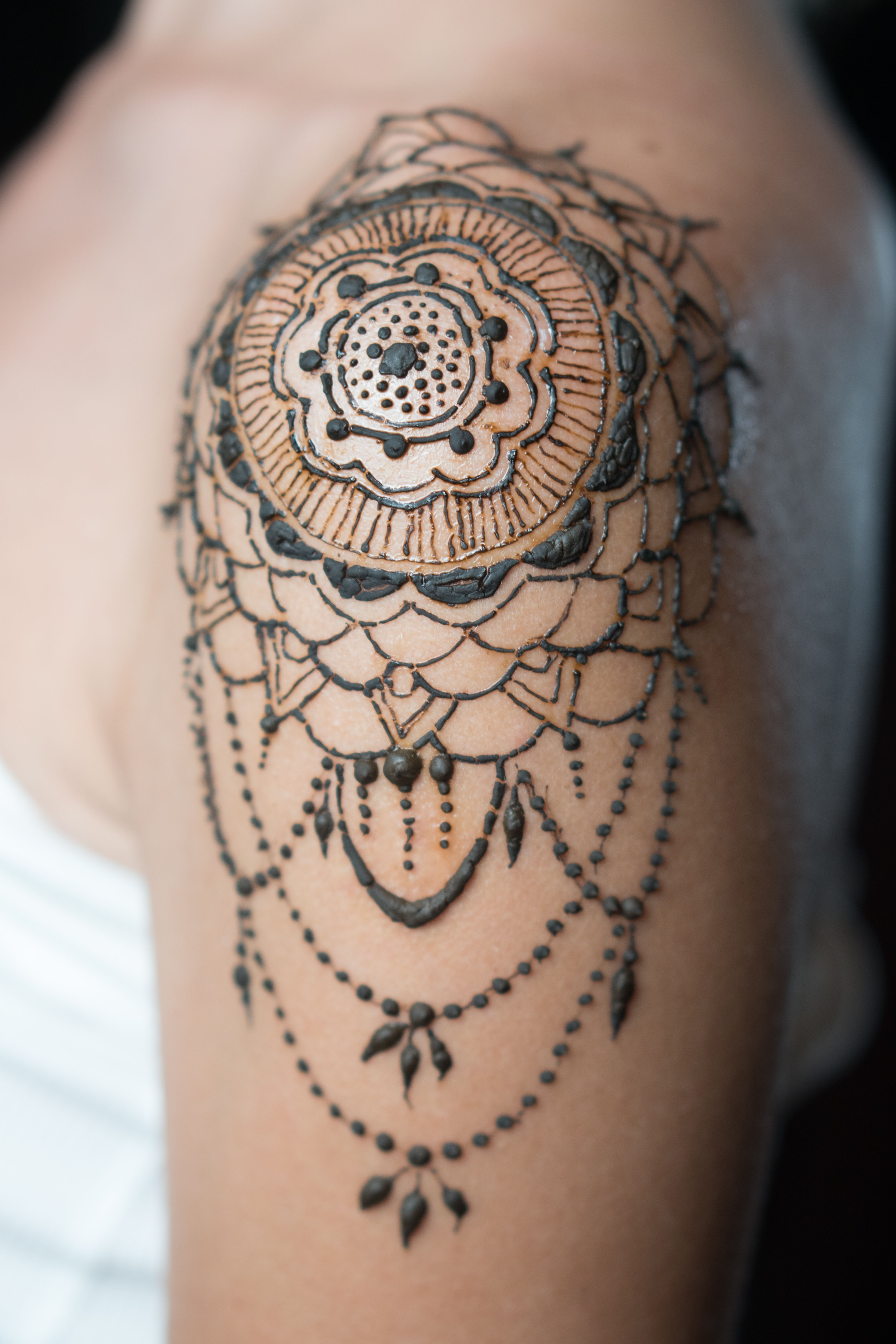 freshly done henna tattoo on woman's shoulder