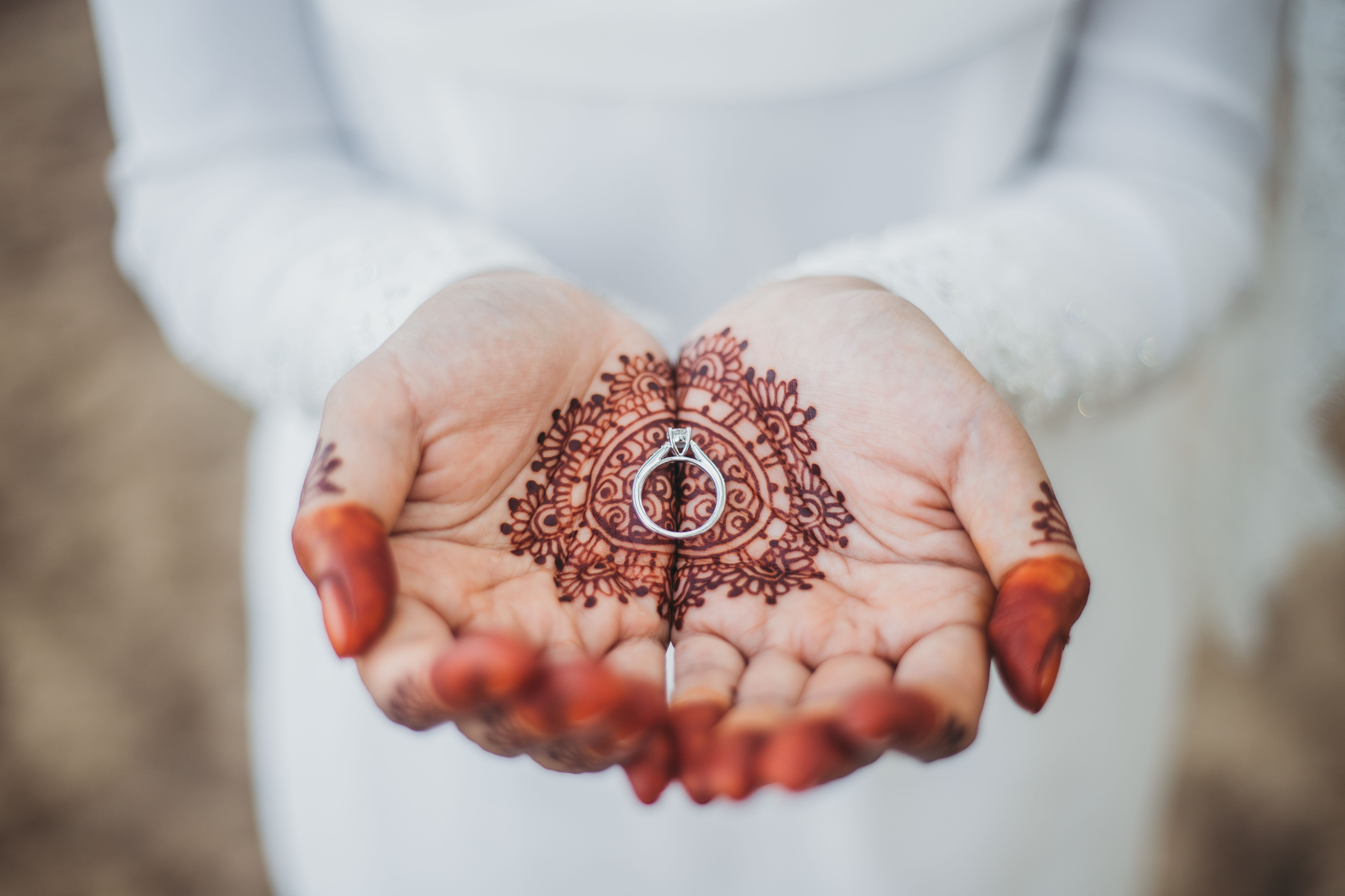 holding a ring with henna
