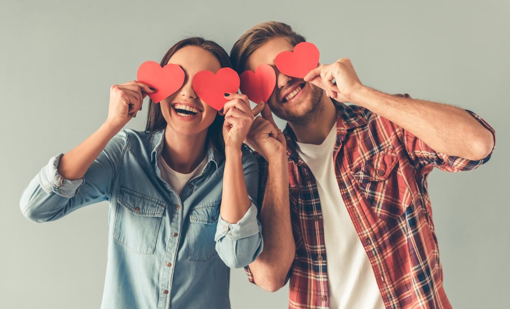 Happy young couples holding hearts