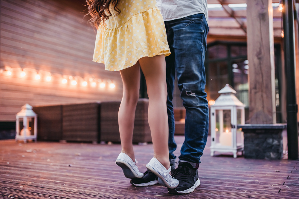 Cropped image of dad and daughter dancing on house's terrace