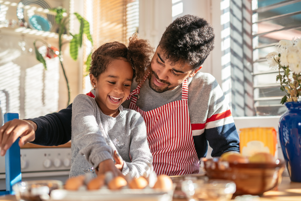 father and daughter baking in the kitchen and having fun