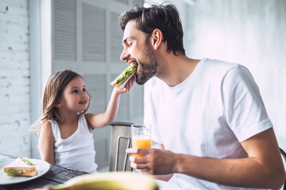 father with his little cute girl having breakfast