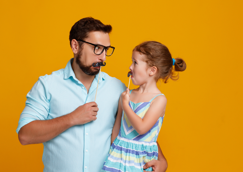 funny dad and daughter with mustache fooling around