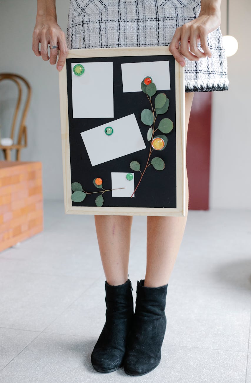 crop woman showing blackboard with papers and decorations