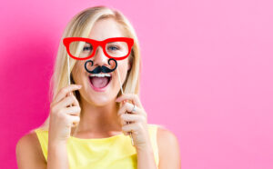 Young-woman-holding-paper-party-sticks-on-a-pink-background