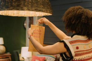 a woman hanging a sale sign on a lamp